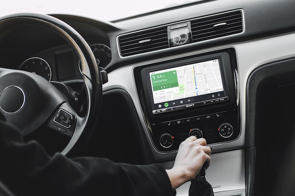 Afbeelding van de 6.95" (17,6 cm) DAB Media Receiver met WebLink Gegoten in een auto met chauffeur die Android Auto-navigatie gebruikt.