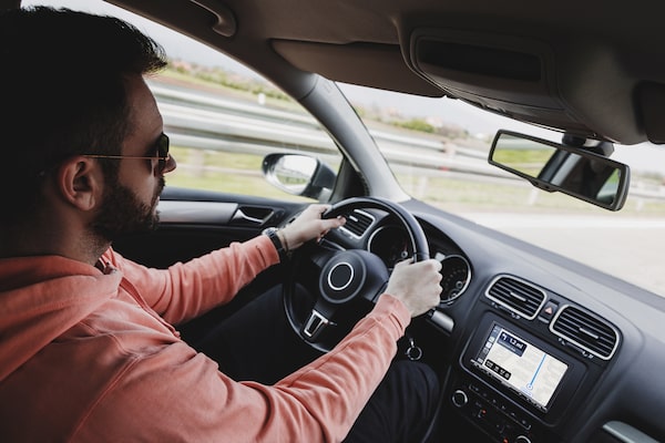 Afbeelding van de 6.95" (17,6 cm) DAB Media Receiver met WebLink Gegoten in een auto met chauffeur die Apple CarPlay-navigatie gebruikt.